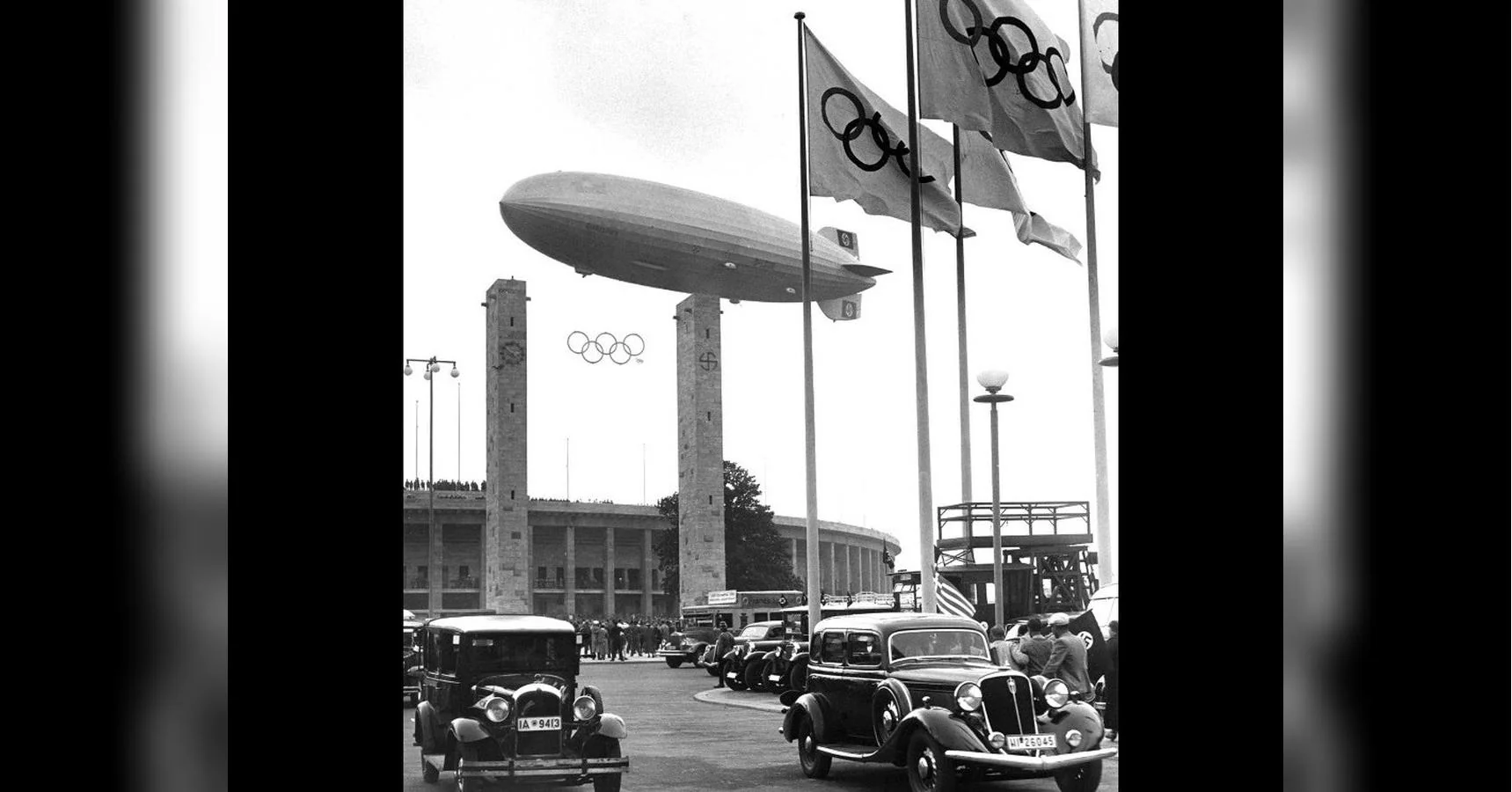 Цепелін над Олімпійським стадіоном Берліна 1936 року з прапорами та ретроавтомобілями